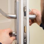 A professional locksmith is fitting a thumb turn lock